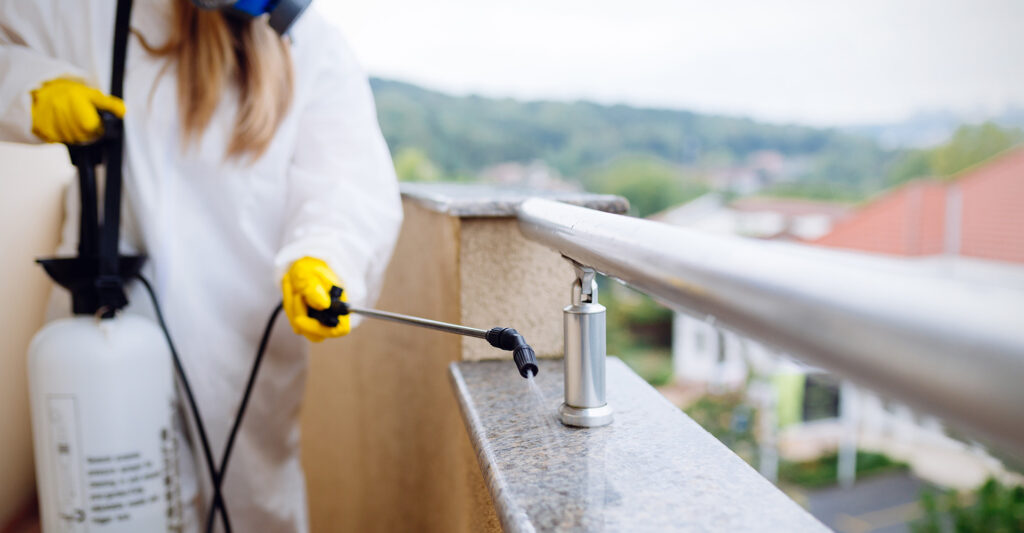 A pest control expert spraying the balcony of a home