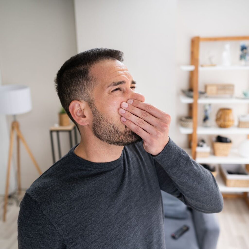 man smelling a bad smell